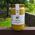 Jar of Healthy Bee Honey on a wooden surface with a natural background